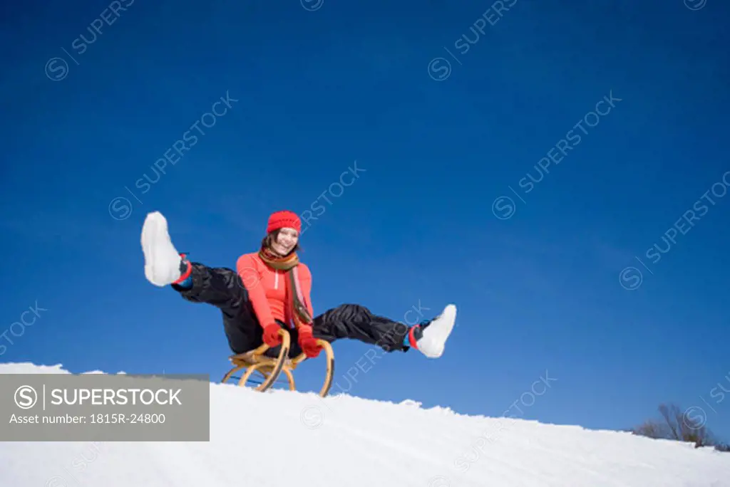 Woman on sledge, smiling, low angle view