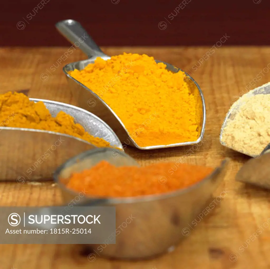 Curry, curcuma, white pepper and chilli powder in scoop, close-up
