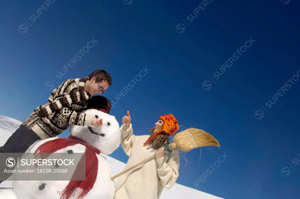 Young couple with snow man