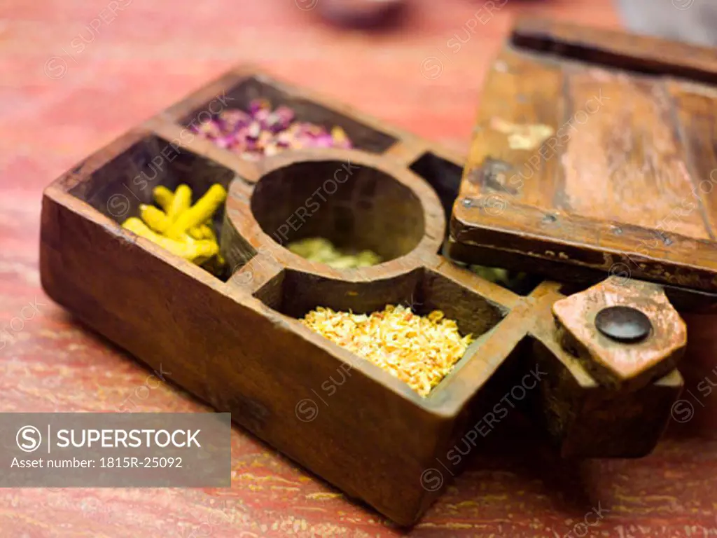 Compartmented wooden box with various spices, close-up