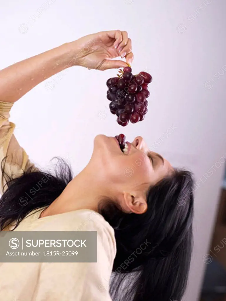 Woman eating grapes, close-up