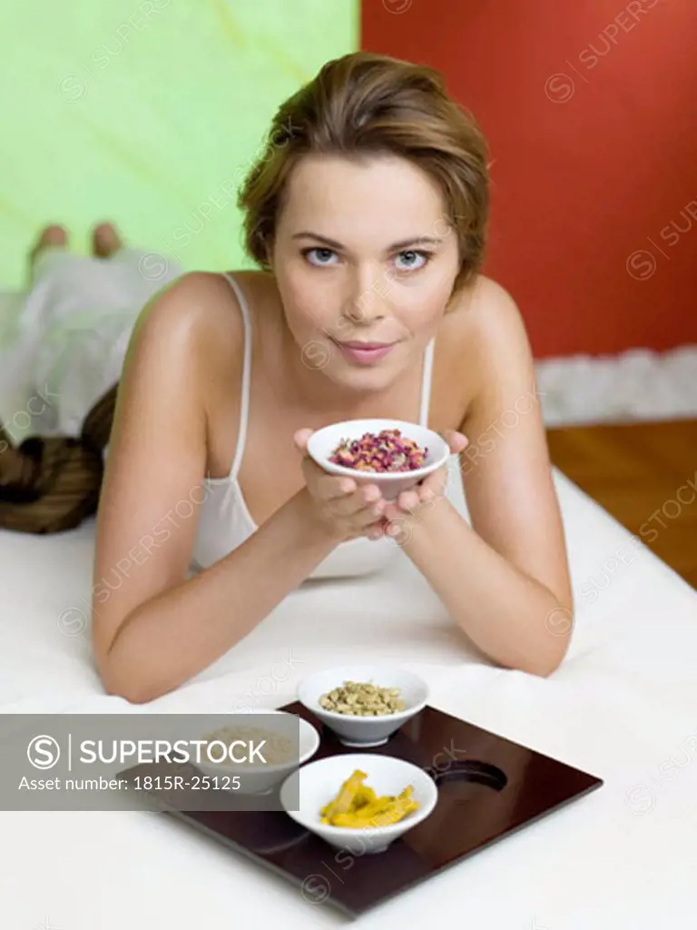 Woman lying on bed with spice in bowls