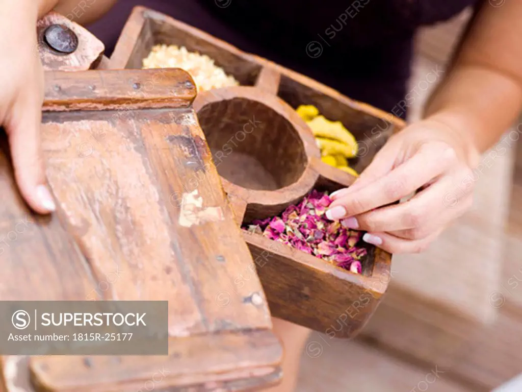Woman holding spice box, mid-section