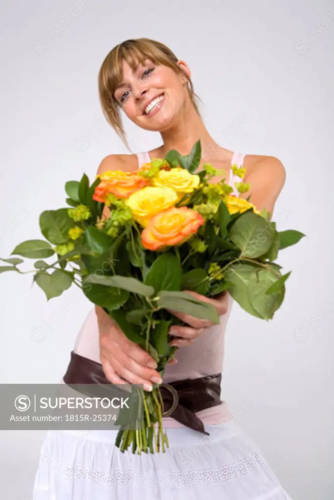 Young woman holding bunch of yellow roses