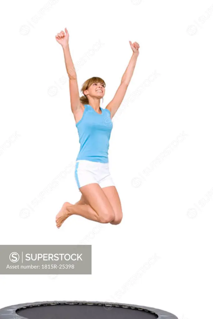 Young woman jumping on trampoline, low angle view