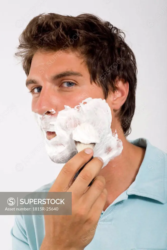Young man shaving, portrait