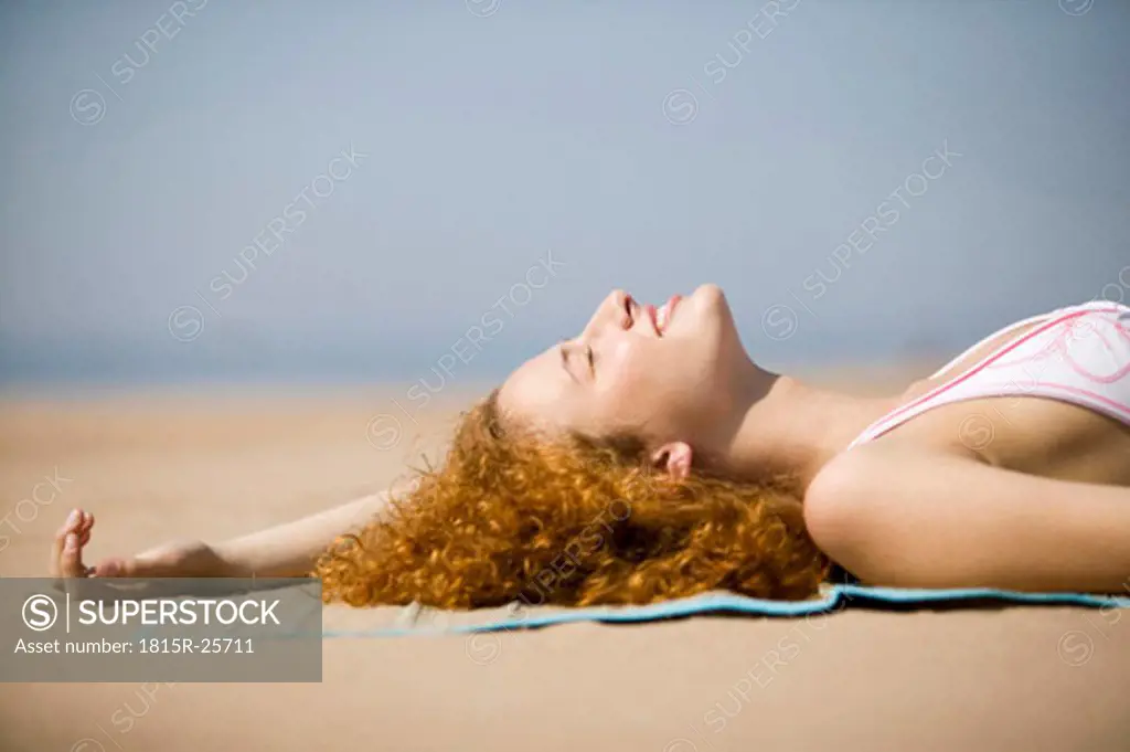Young woman relaxing on beach, close-up