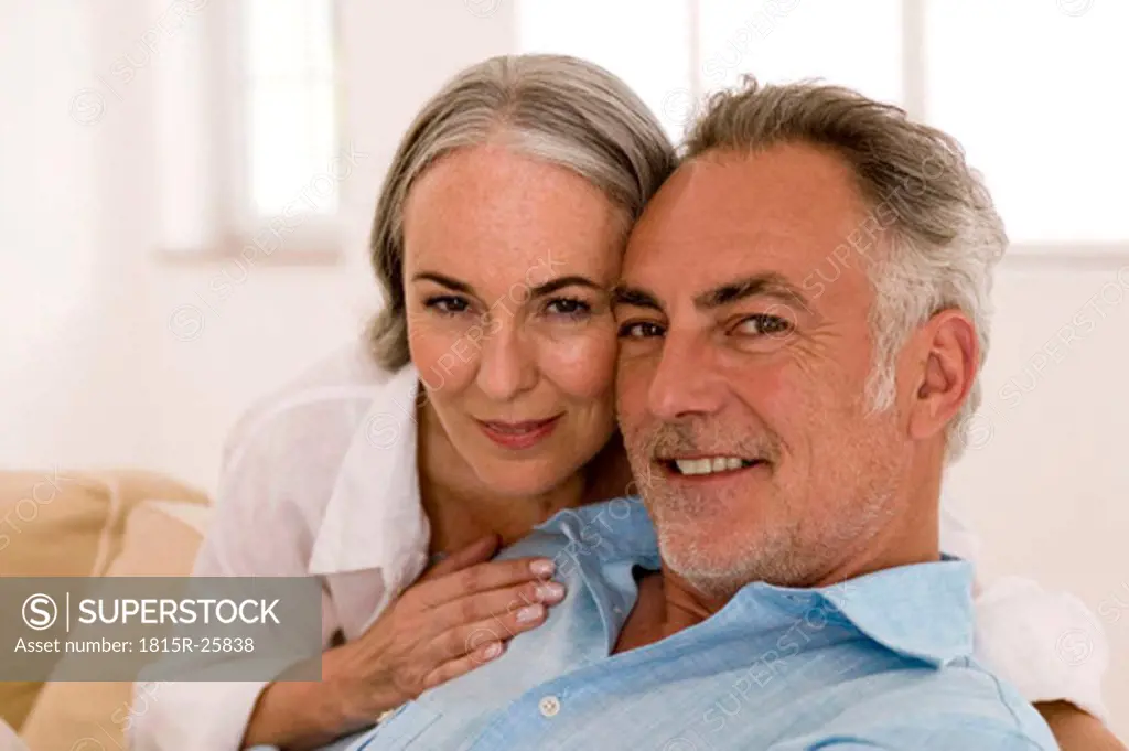 Mature couple in living room, close-up, portrait