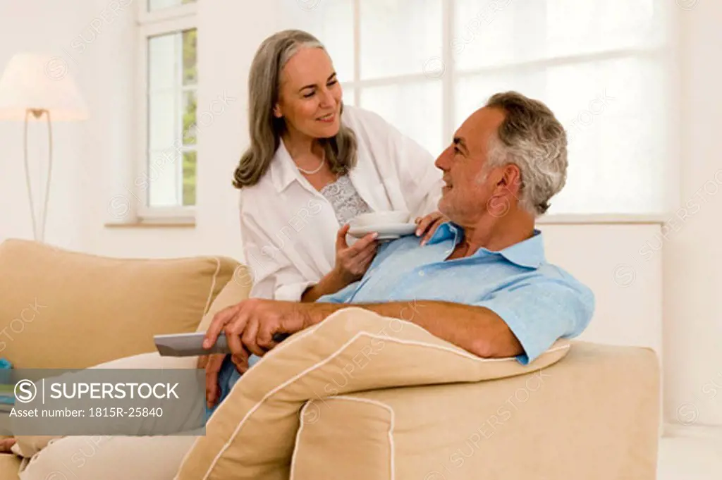 Mature couple in living room, smiling, close-up