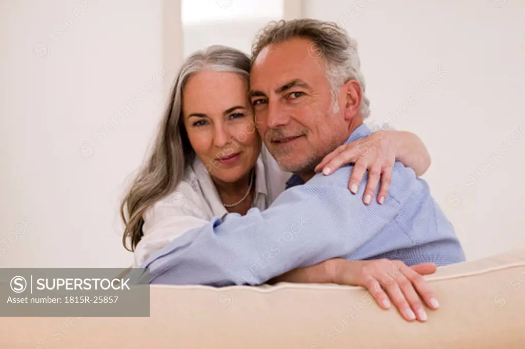 Mature couple embracing on sofa, close-up, portrait