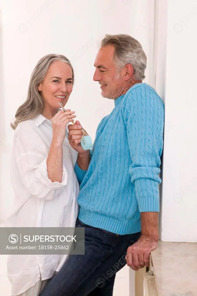 Mature couple holding key, smiling