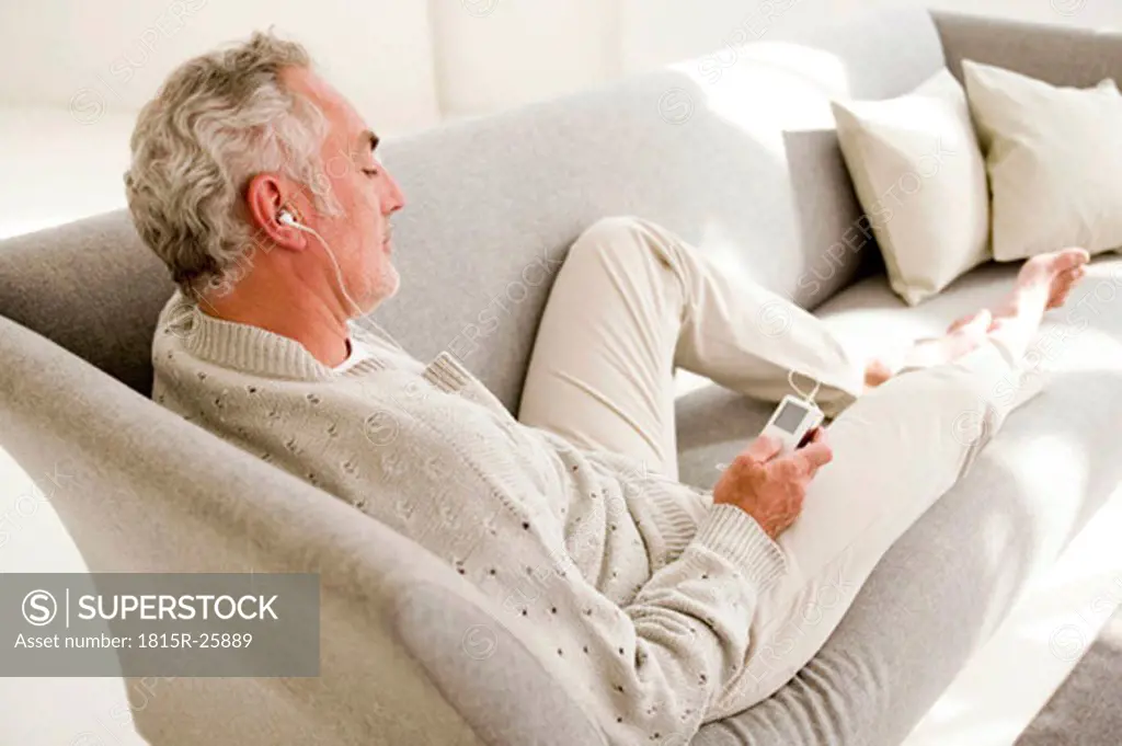 Mature man listening to MP3 player, elevated view