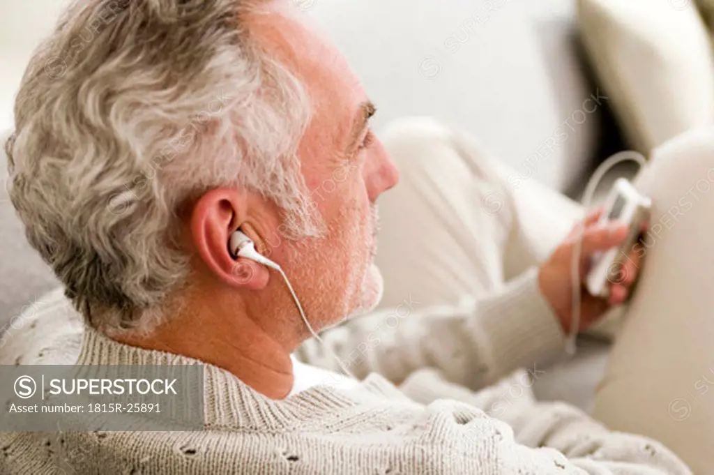 Mature man listening to MP3 player, close-up