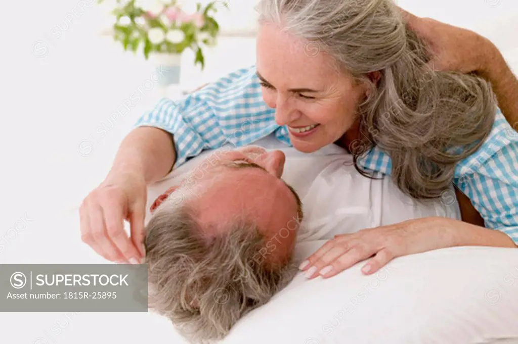 Mature couple embracing in bed, close-up