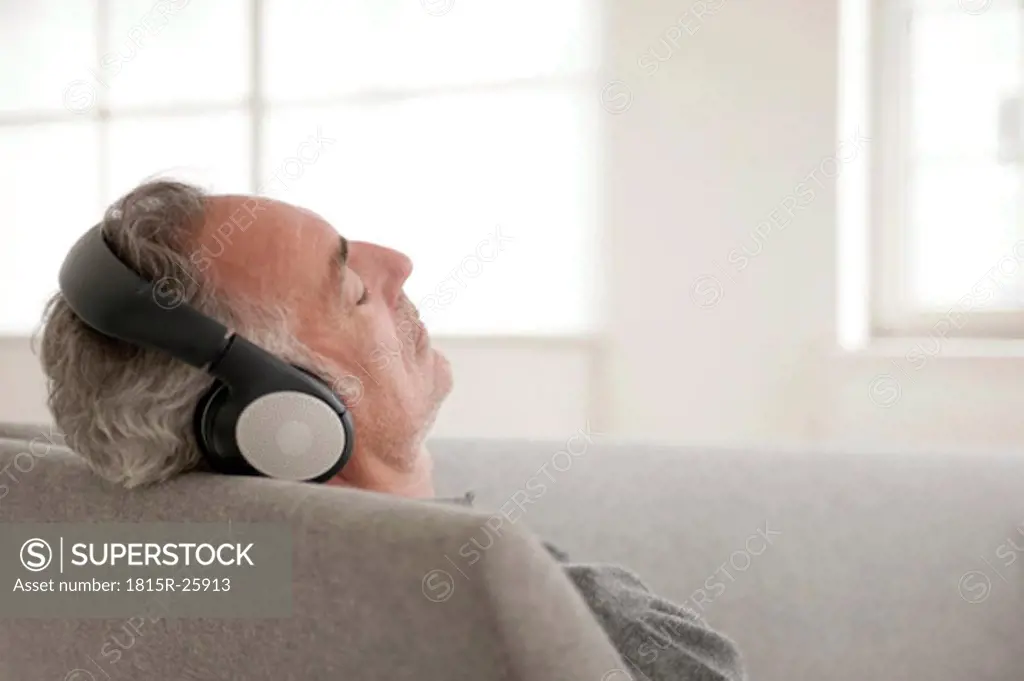 Mature man wearing headphones, eyes closed