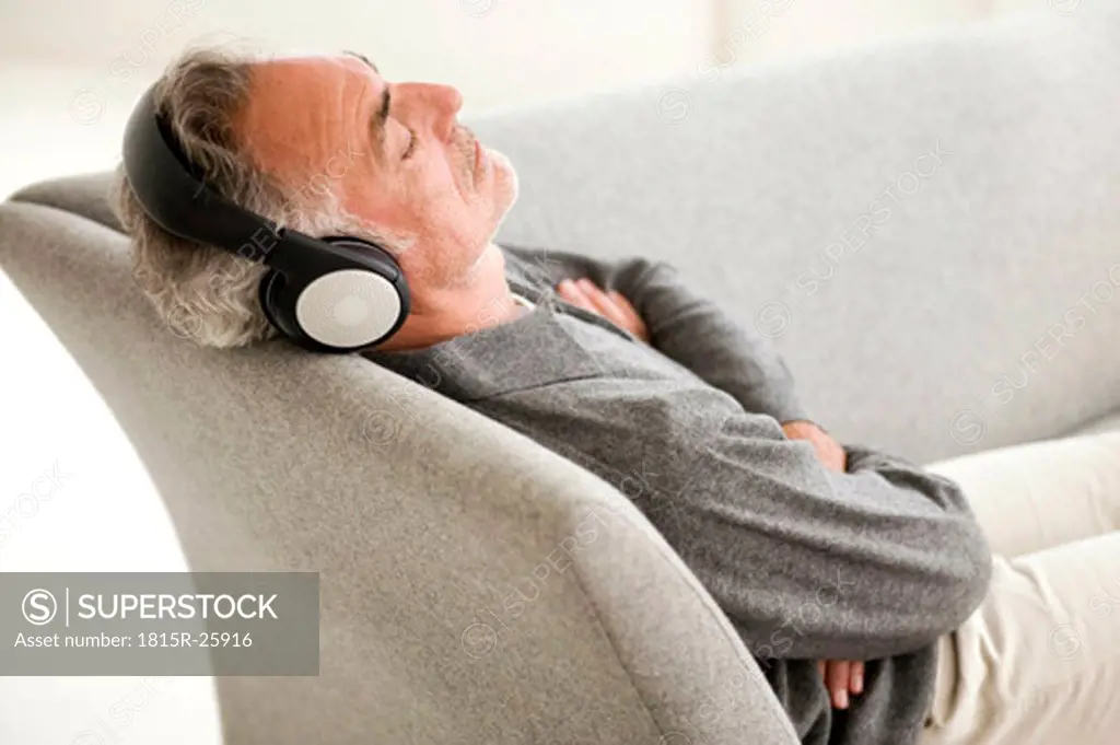 Mature man wearing headphones, eyes closed, elevated view