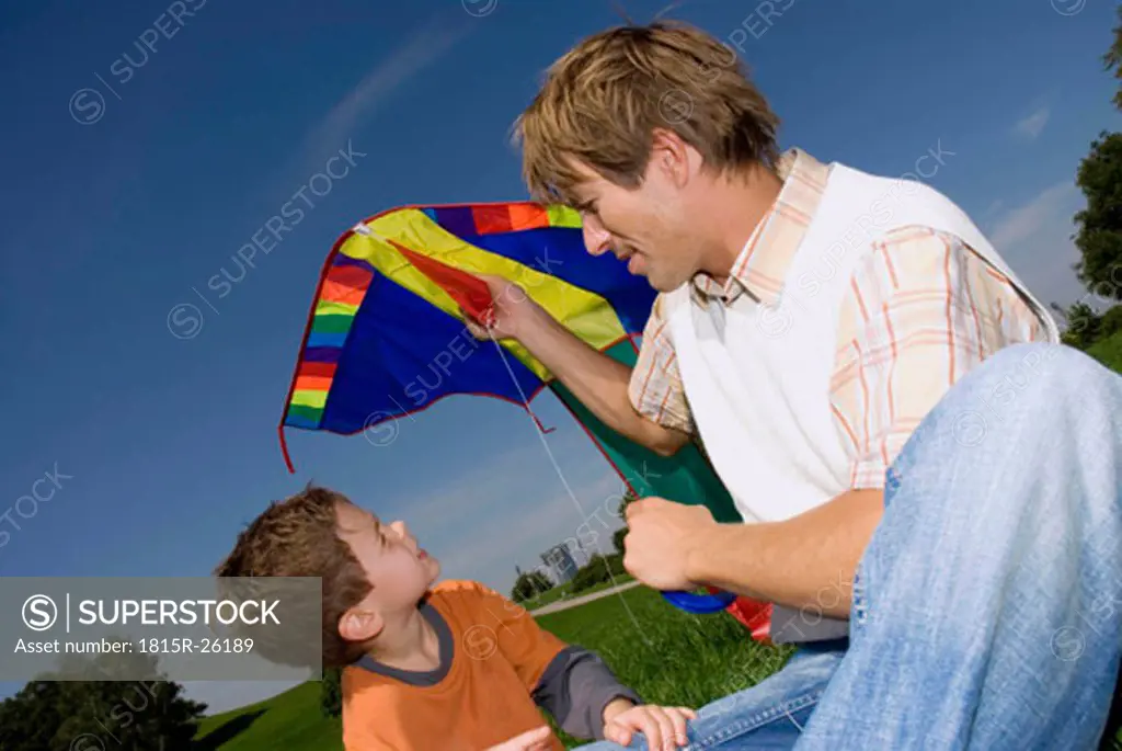 Father and son (4-7) with kite, close-up