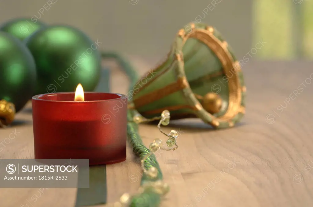 Christmas decoration with burning candle and christmas baubles