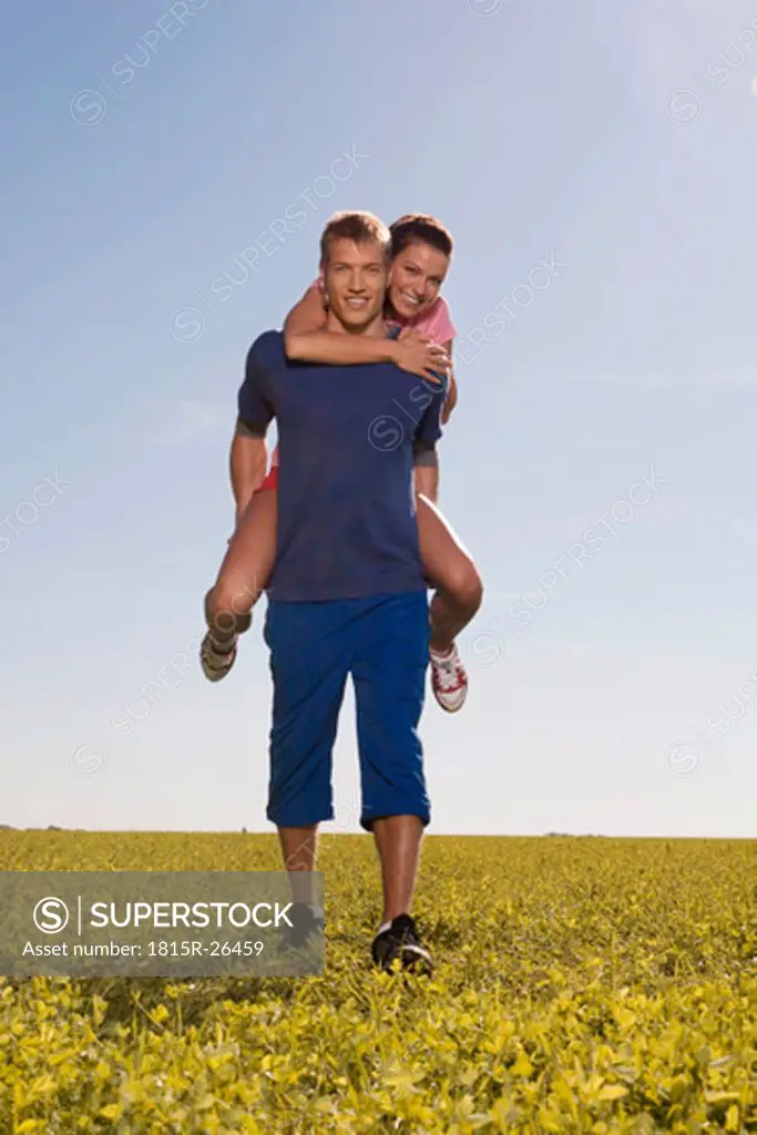 Young man carrying woman on back