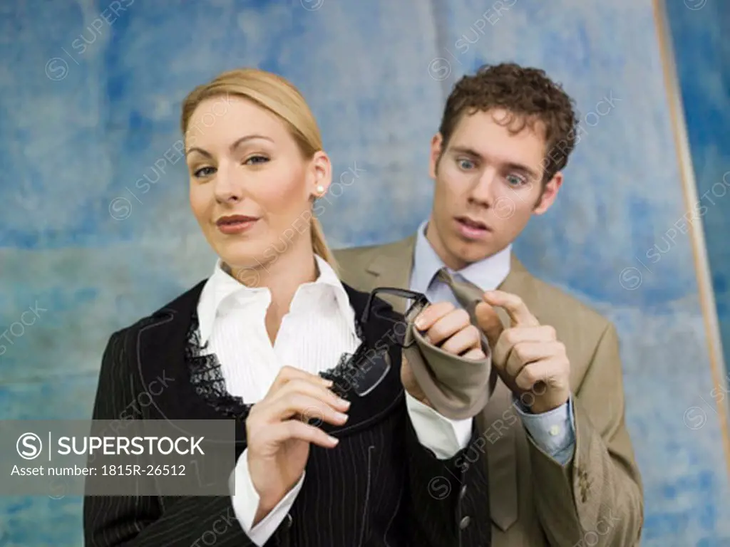 Business woman cleaning spectacles with man´s tie