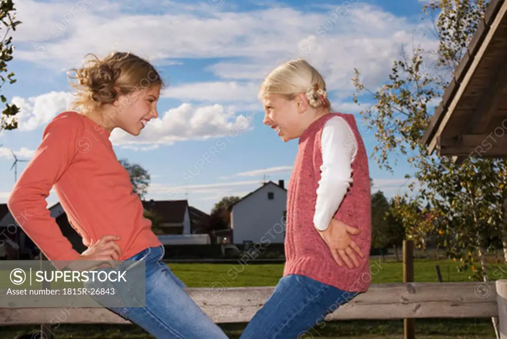 Two girls on wooden railing