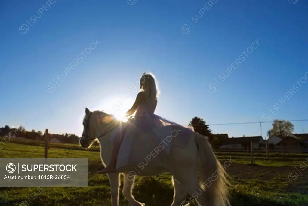 Girl dressed as princess, riding horse