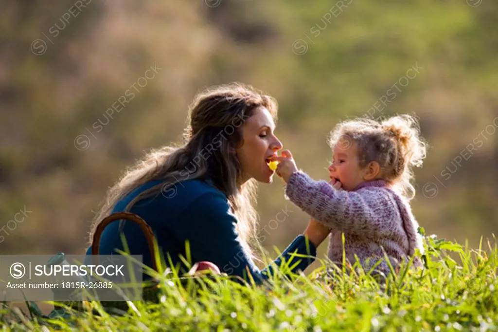 Daughter feeding mother, side view