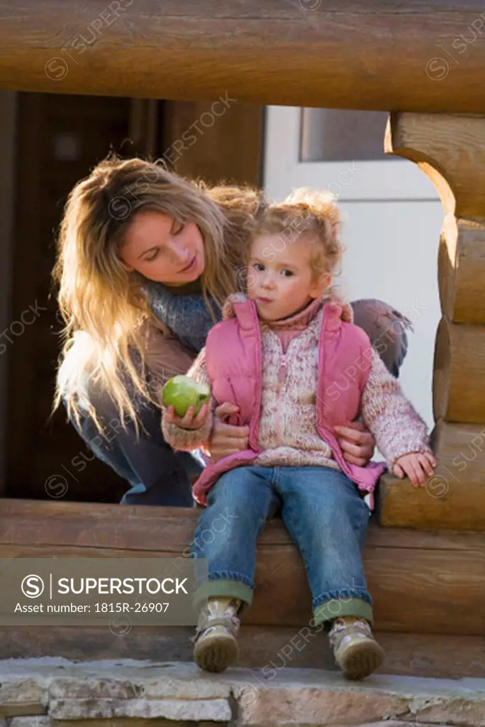 Mother with daughter, daughter holding apple