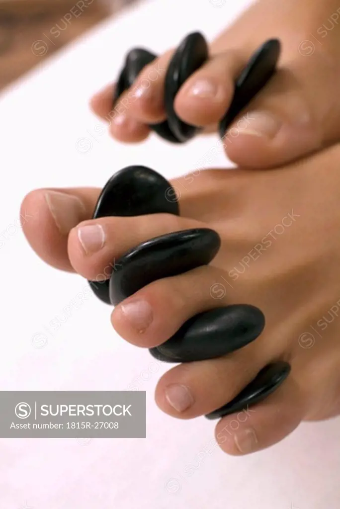 Woman receiving foot treatment with hot stones