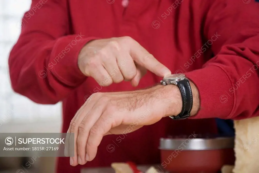Man pointing on wristwatch