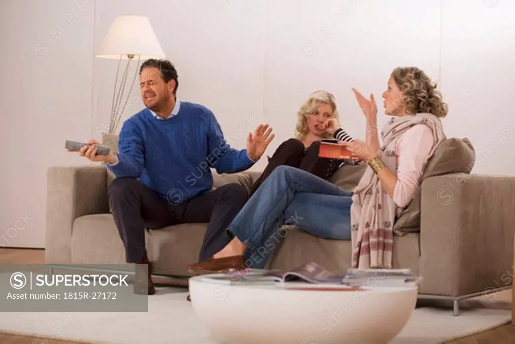 Parents with daughter sitting on sofa in living room