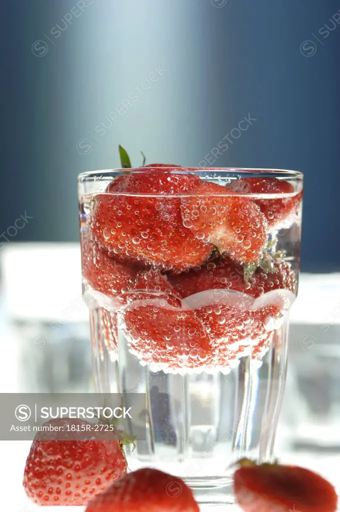 Strawberries in glass of water, close-up