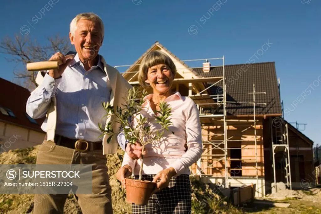 Senior couple in front of partially built house
