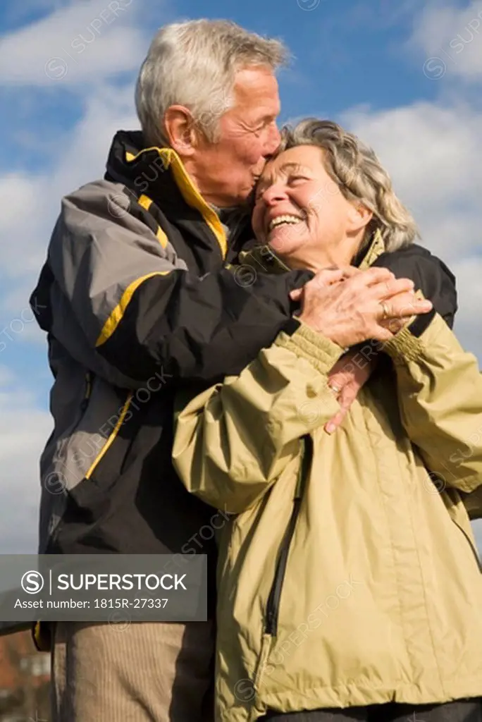 Senior couple, man kissing woman, smiling