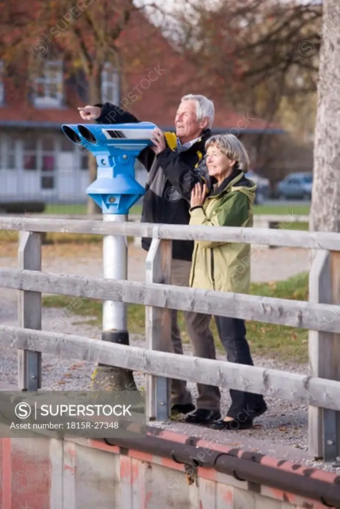 Senior couple on jetty, man pointing