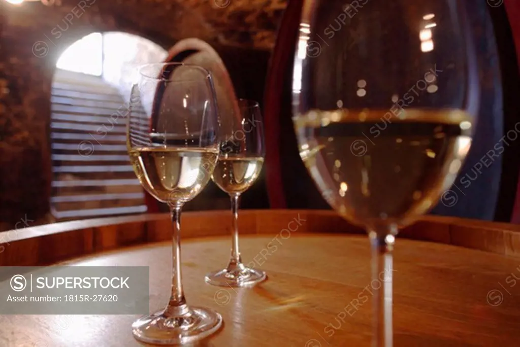 Wite wine in glasses on wine cask