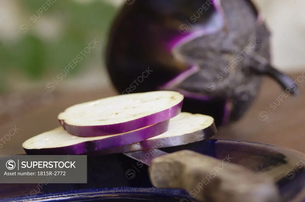 Sliced eggplant on knife and plate, close-up