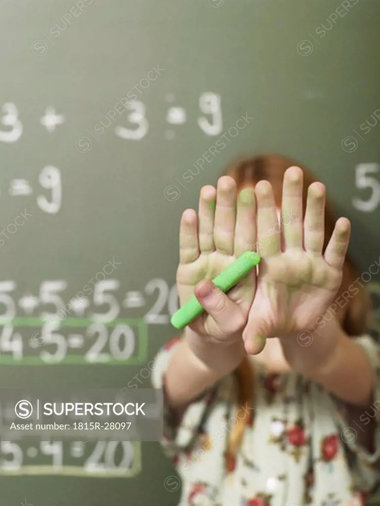 Girl standing in front of blackboard