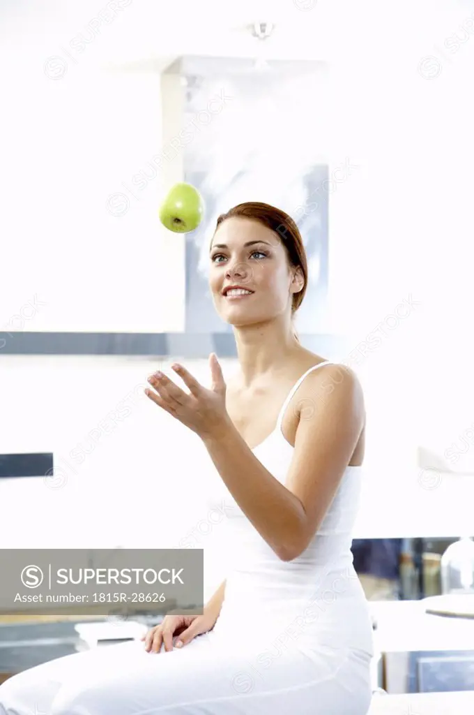 Youong woman throwing apple