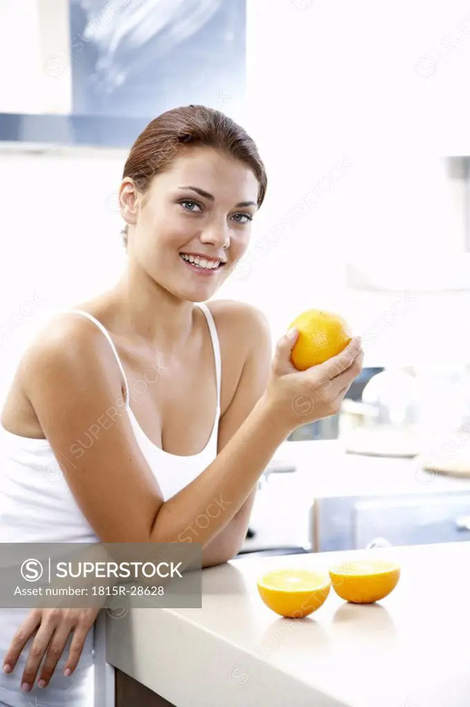 Young woman holding orange