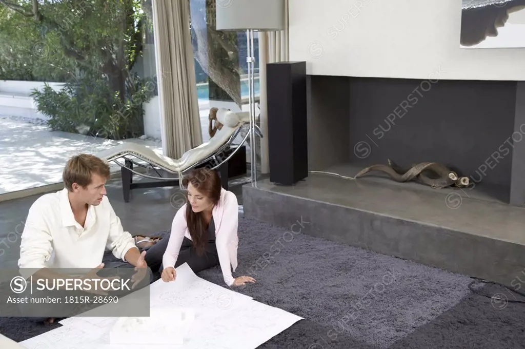 Couple in living room with construction plans