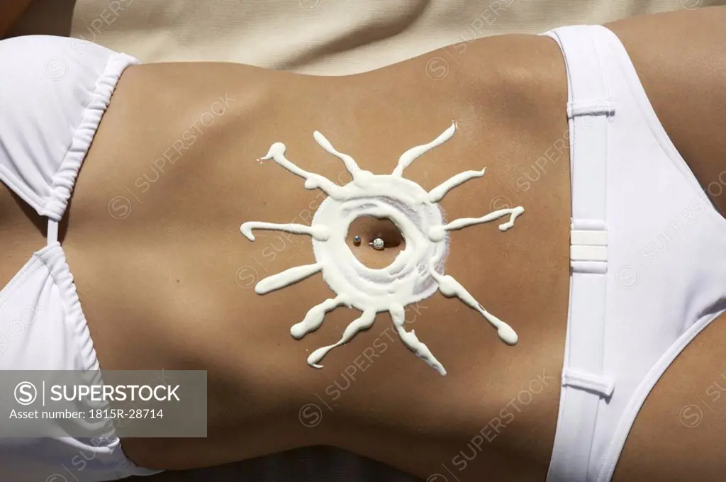 Woman with sun-shaped sun creme on belly