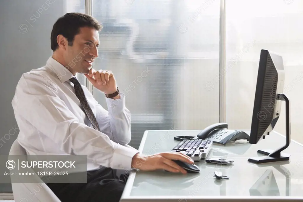Business man sitting at desk, portrait