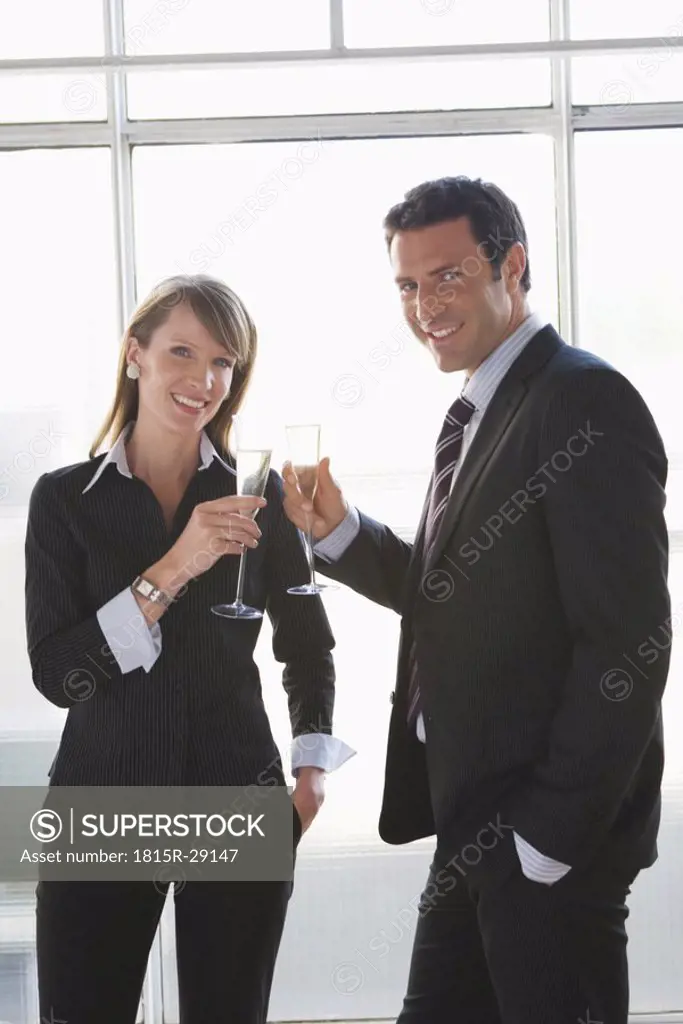 Business woman and man toasting with sparkling wine