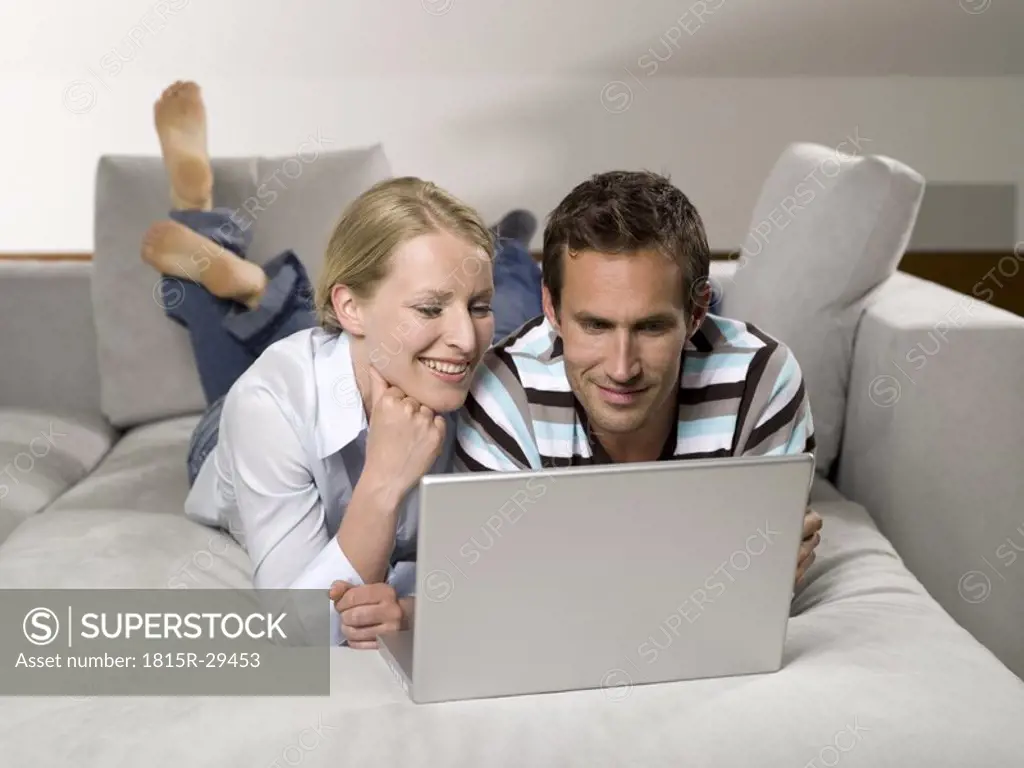 Couple on sofa, using laptop
