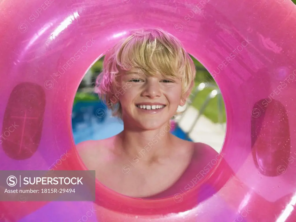 Boy holding pink rubber ring, portrait