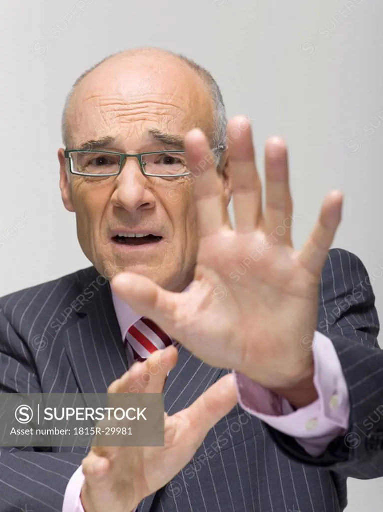 Senior businessman making a stop gesture, portrait