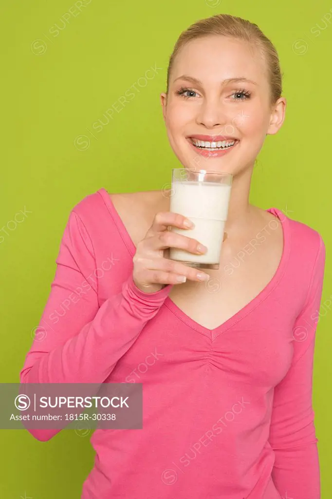 Young woman drinking a glass of milk, portrait
