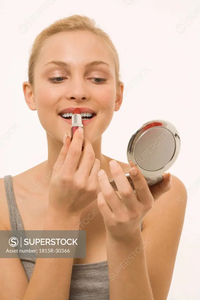 Young woman painting lips, portrait