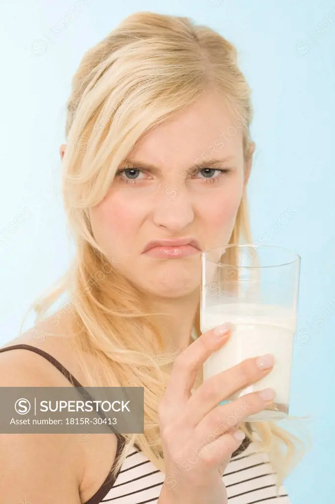 Woman drinking glass of milk, portrait